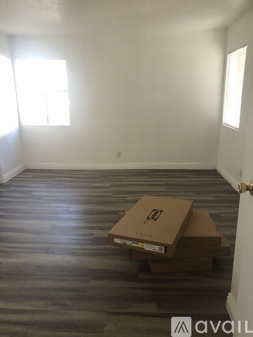 A room with a wooden floor and a cardboard box on it.