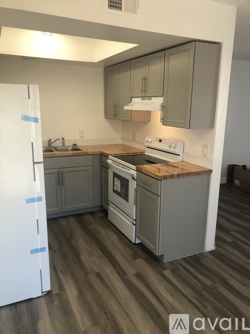 A kitchen with a white refrigerator and wooden countertops.