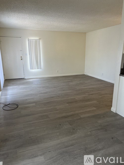A room with wooden flooring and a white door.