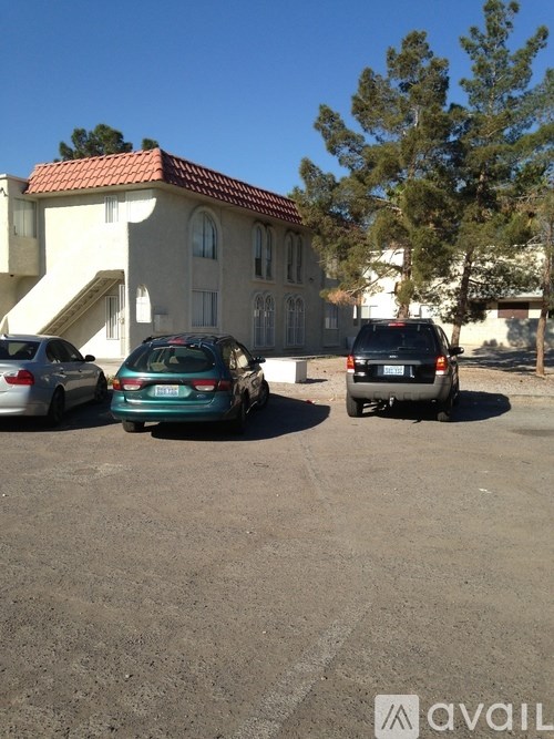 A car is parked in a lot in front of a house.