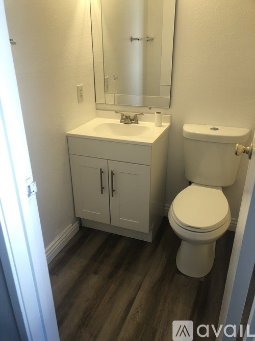 A white toilet sits next to a sink in a small bathroom.