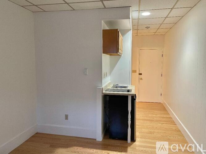 A room with a desk and a cabinet in it.