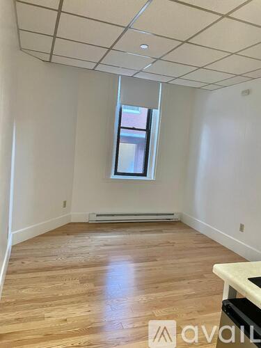 A room with wooden flooring and a window.