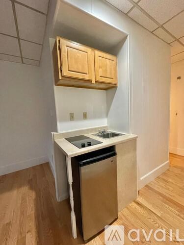 A kitchen with wooden cabinets and a stainless steel dishwasher.