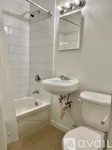 A white bathroom with a sink, toilet, and bathtub.