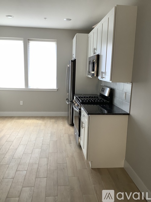 A kitchen with a black counter top and white cabinets.