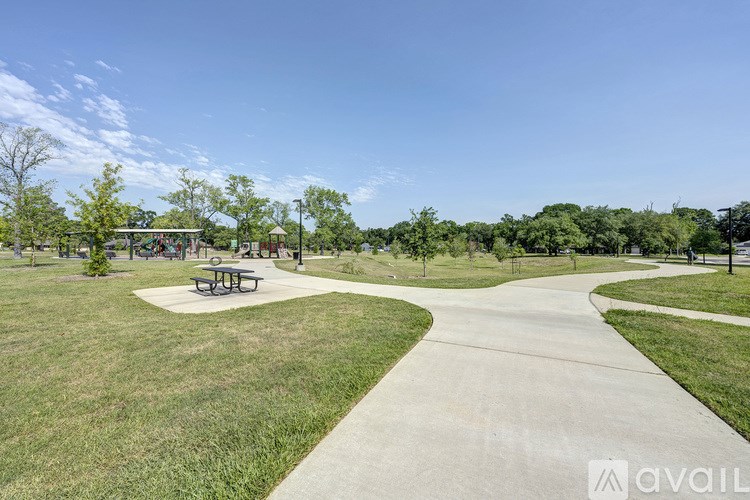 A park with a picnic table and a walking path.