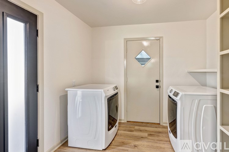 A room with two ovens and a door with a diamond pattern.