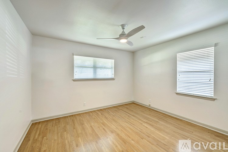 A room with wooden flooring and a ceiling fan.