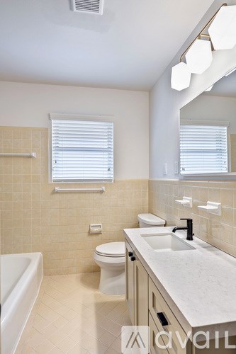 A bathroom with a white tub, toilet, and sink.