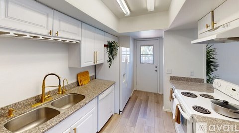 A kitchen with white cabinets and a granite countertop.