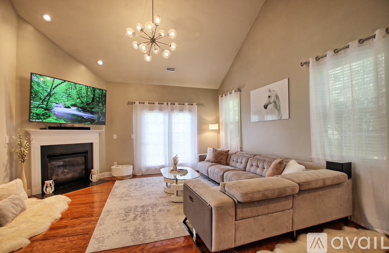 A living room with a fireplace and a television on the wall.
