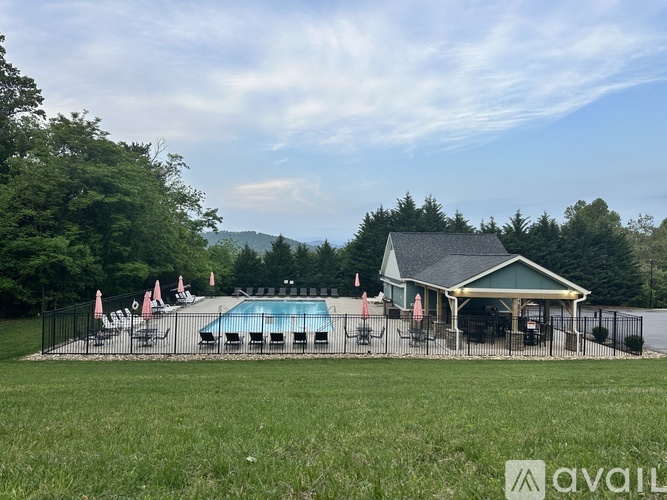 A pool area with a building and chairs.