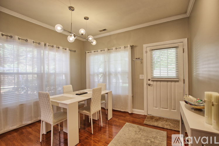 A dining room with a table and chairs.
