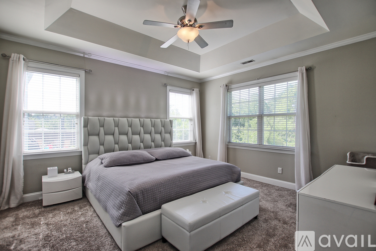 A bedroom with a large bed and a ceiling fan.