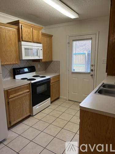 A kitchen with wooden cabinets and a black stove top oven.