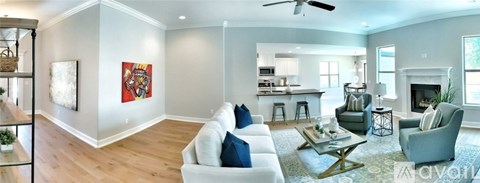 A living room with a white couch and a fireplace.