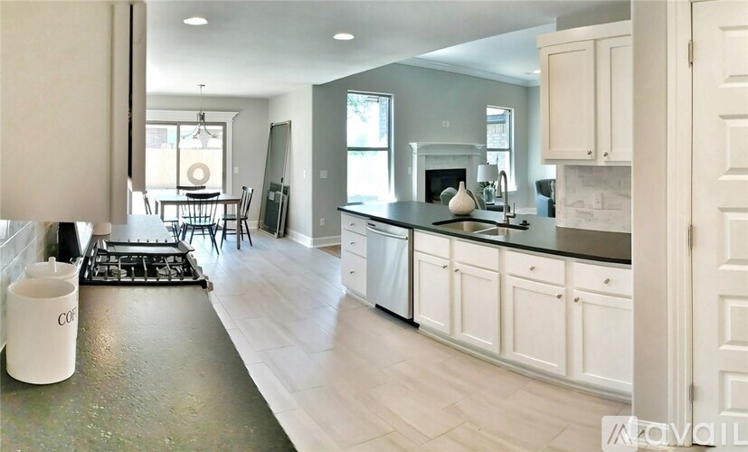 A kitchen with white cabinets and a black stove top.