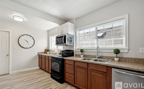 A kitchen with wooden cabinets and a black oven.
