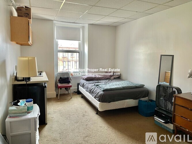 A bedroom with a bed, desk, and chair.