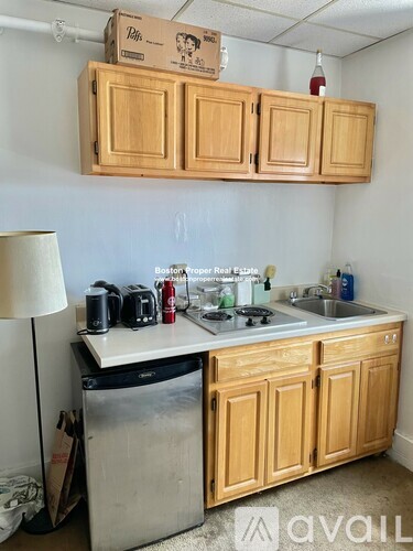 A kitchen with wooden cabinets and a box on top of them.