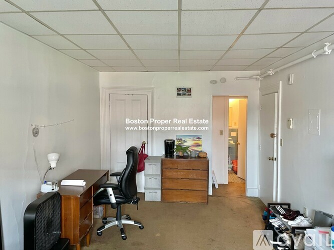A room with a desk and a chair in it.