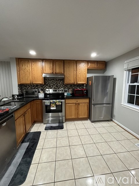 A kitchen with wooden cabinets and a black countertop.