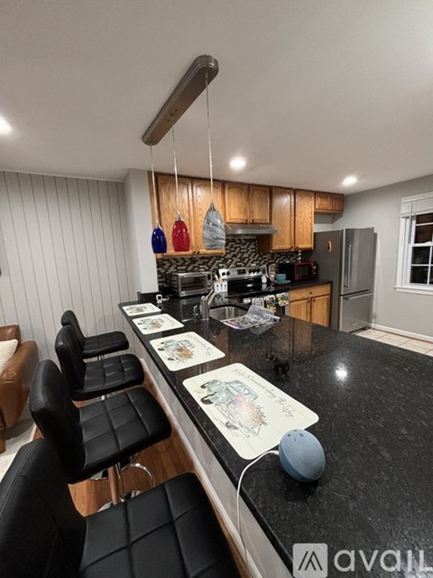 A kitchen with a black countertop and a blue ball on it.
