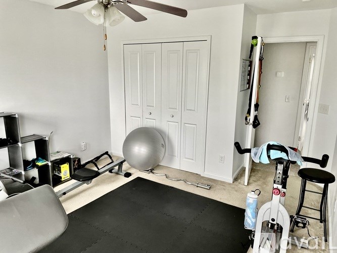 A room with a grey exercise ball and a white door.