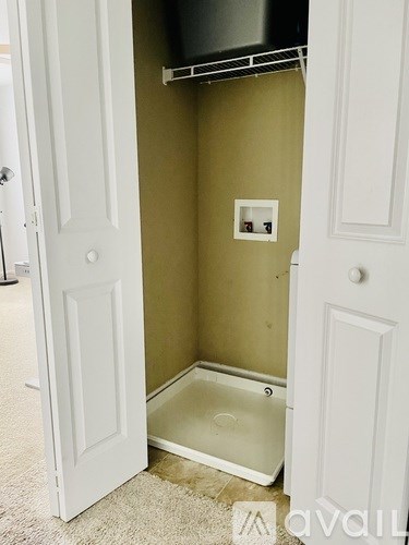 A white door is open to a small bathroom.