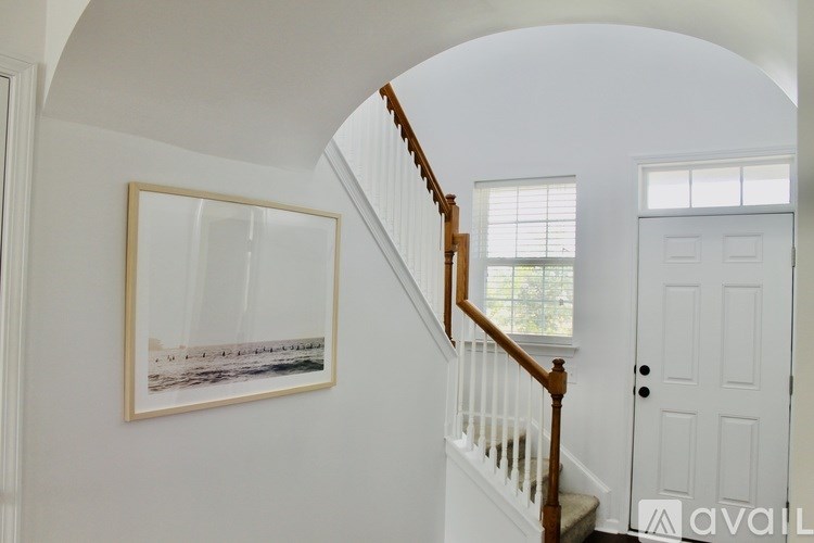 A white door is on the right side of a staircase.