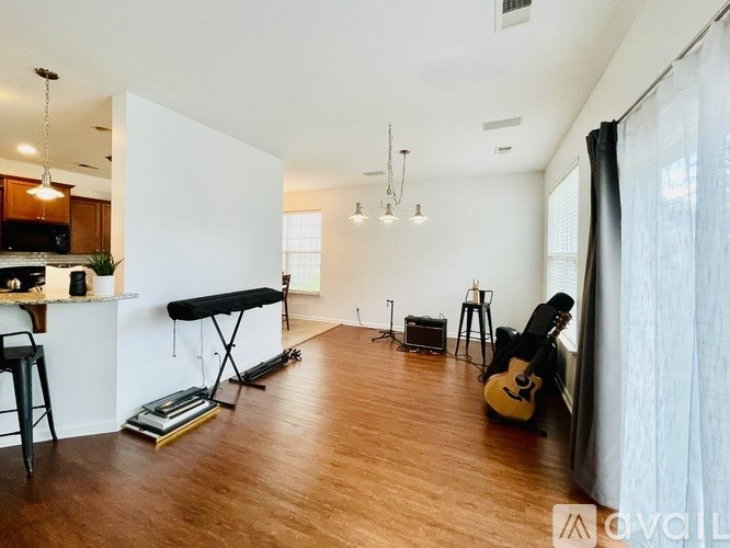 A room with a piano, guitar, and drum set.