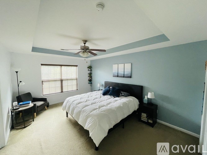 A bedroom with a bed, nightstand, and window.