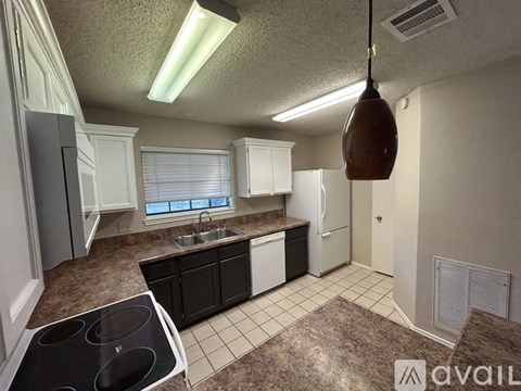 A kitchen with brown carpeting and white cabinets.