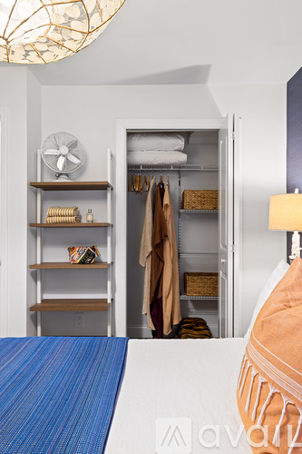 A room with a blue rug and a white wall.