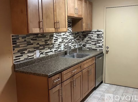 A kitchen with wooden cabinets and a granite countertop.