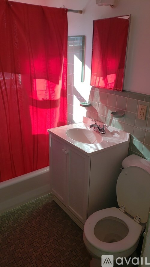 A bathroom with red curtains and a white sink.