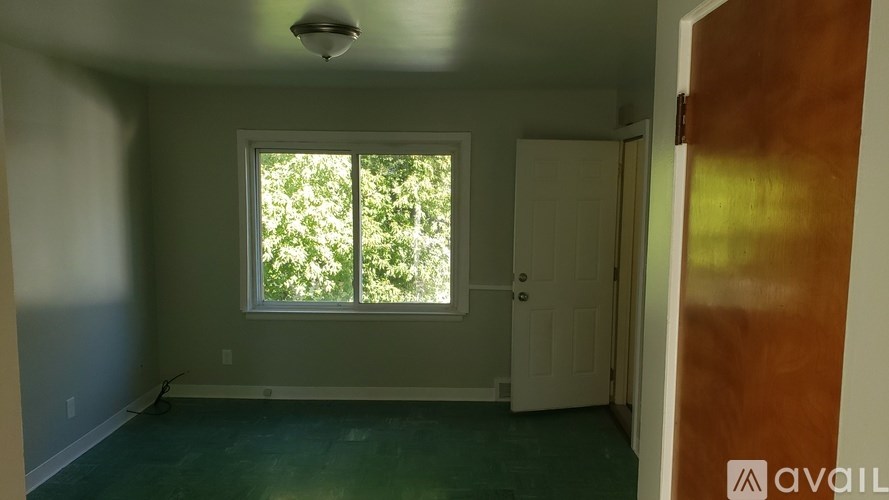 A room with a window and a door is available for rent.