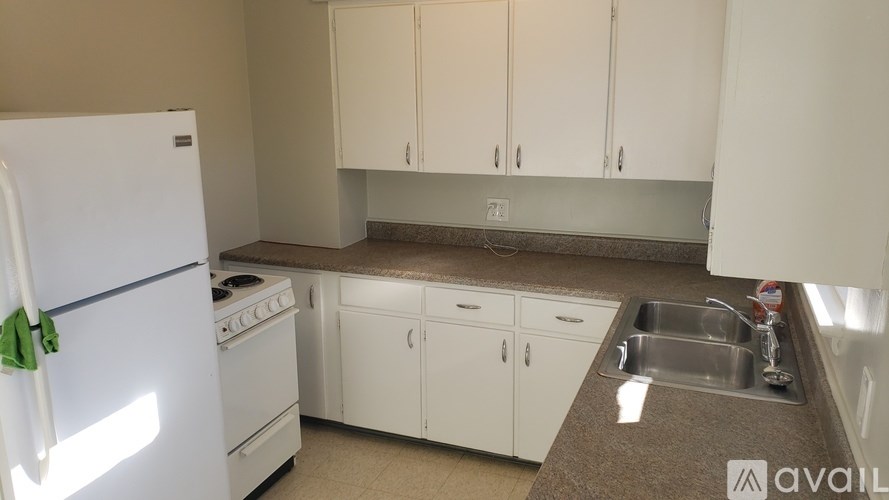 A kitchen with white appliances and cabinets.