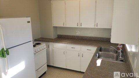 A kitchen with white appliances and cabinets.