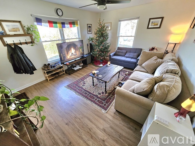 A living room with a fireplace and a Christmas tree.