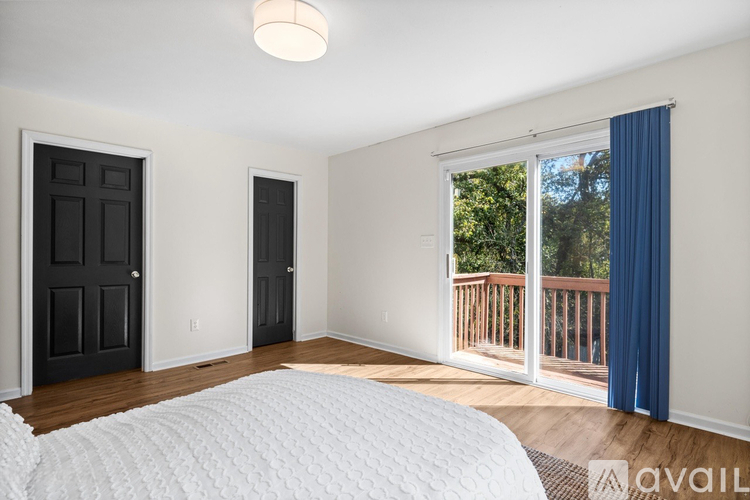 A bedroom with a large bed and a balcony.