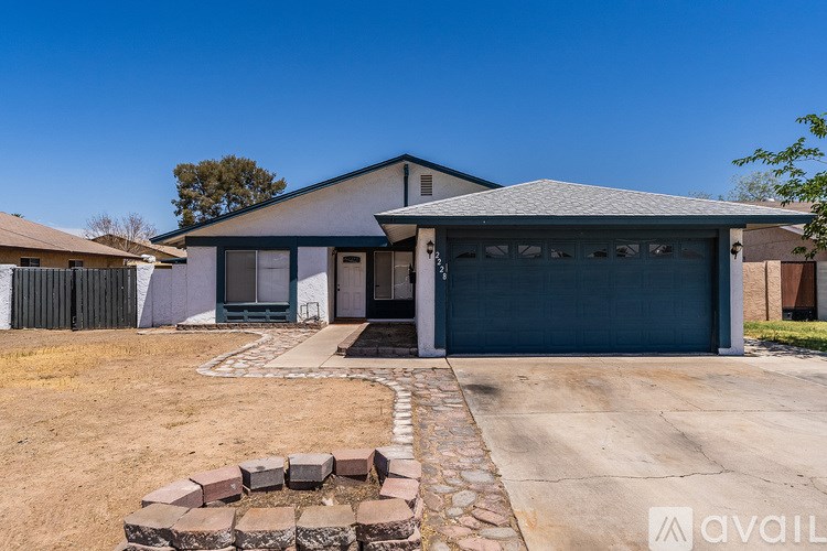 A house with a garage and a driveway with a stone circle in front.