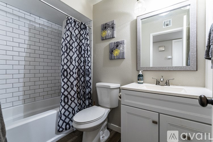 A bathroom with a toilet, sink, and a mirror.