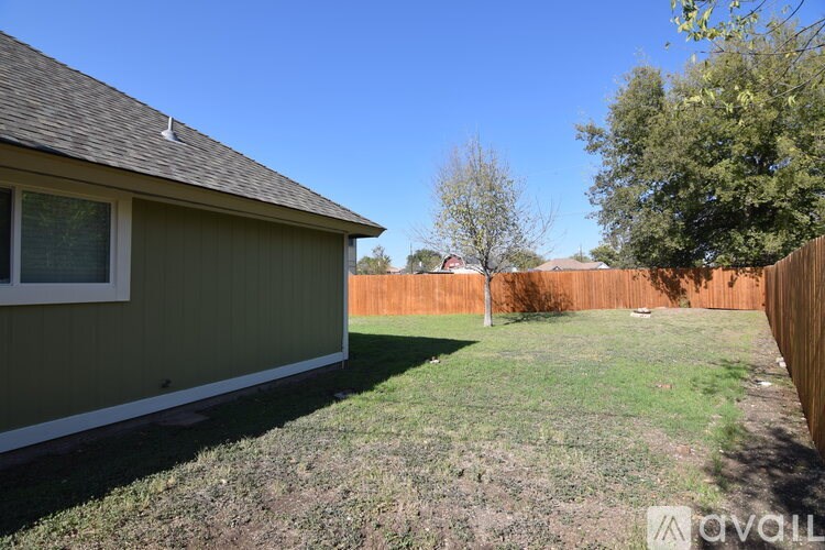 A backyard with a fence and a house.