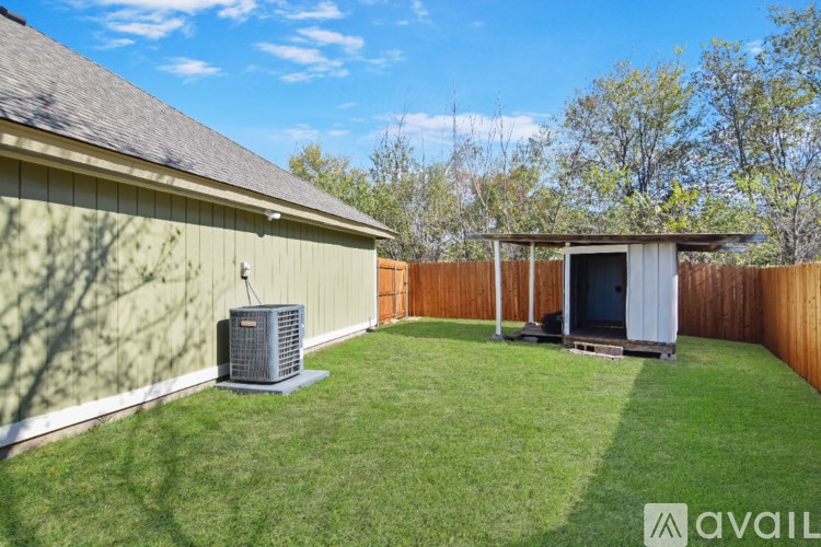 A backyard with a shed and a fence.