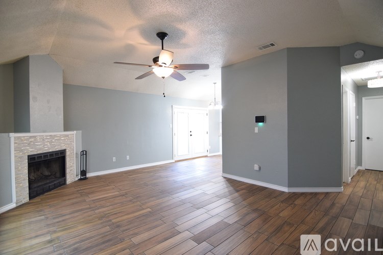A living room with a fireplace and wood flooring.