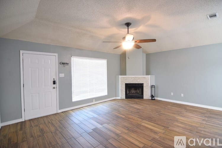 A room with a fireplace and a ceiling fan.