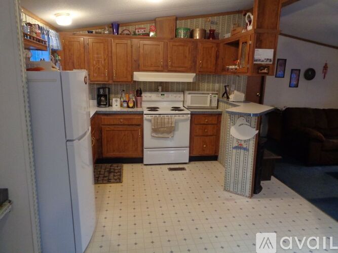 A kitchen with white appliances and wooden cabinets.