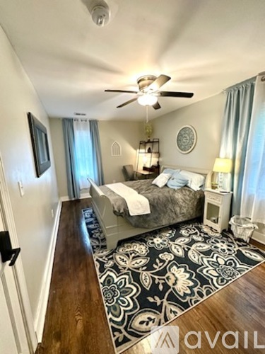 A bedroom with a bed, nightstand, and a rug.